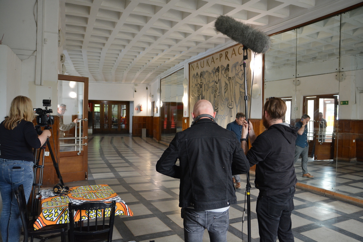 ekipa filmowa z wojewódzkiwgo domu kultury w holu parku kultury przygotowuje się do zdjęć.